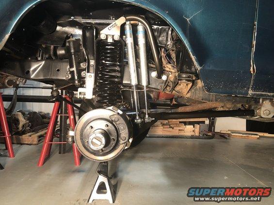 close-up of vehicle's rear suspension with shocks and springs on jack stands