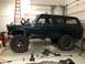 1979 Ford Bronco - This 1979 Ford Bronco is undergoing modifications in a garage, with its hood up and tools nearby.
