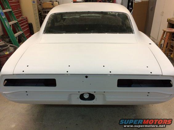 Rear view of a 1969 Chevrolet Camaro body, primed and ready for paint, in a workshop