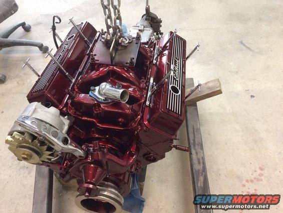 V8 engine with Edelbrock valve covers, being lifted by chains