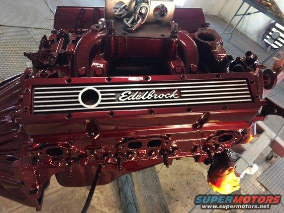 Red Edelbrock intake manifold on a V8 engine block, viewed from the front