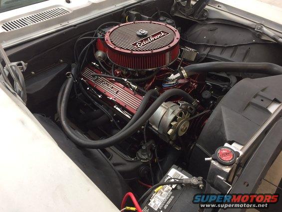 Engine bay with a red Edelbrock air cleaner and valve covers on a V8 engine