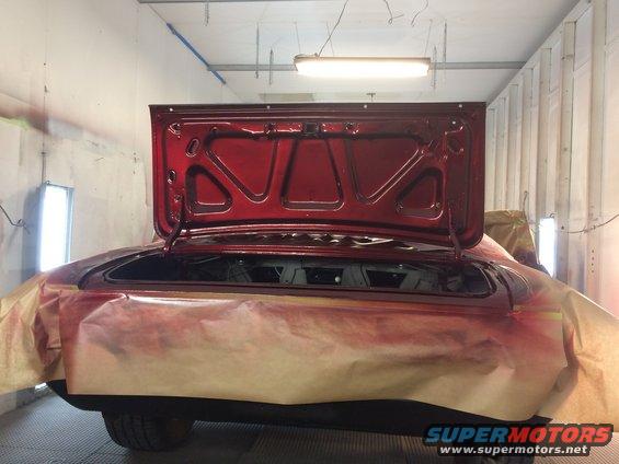 Red 1969 Chevrolet Camaro rear with trunk open, being prepped in a paint booth