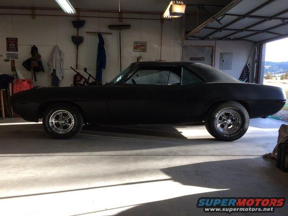 Black 1969 Chevrolet Camaro coupe in a garage, side view