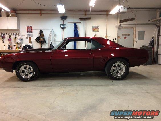 Red 1969 Chevrolet Camaro coupe, side view, in garage