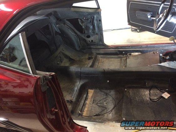 1969 Chevrolet Camaro interior stripped down for restoration, showing bare floor and door panels