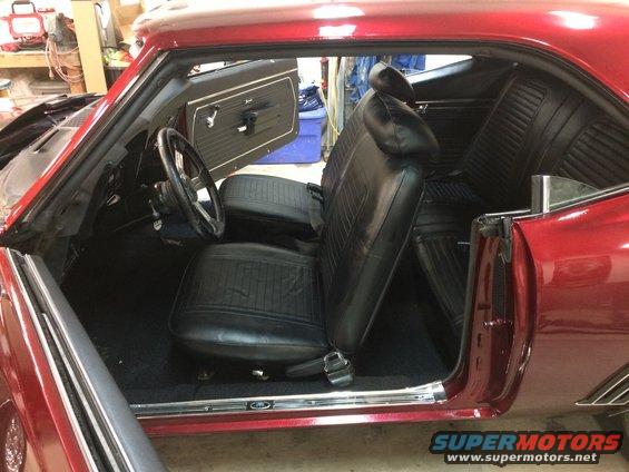 1969 Chevrolet Camaro interior, showing black vinyl seats, dashboard, and door panel