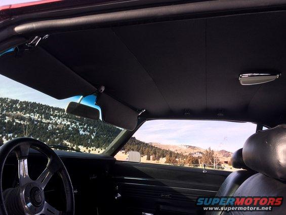 Interior of a 1969 Chevrolet Camaro showing black seats, sun visors, and steering wheel