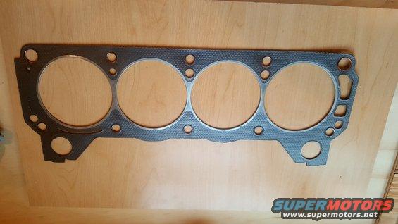 Engine gasket with four large cylinder openings and multiple bolt holes