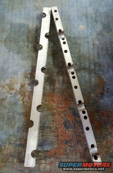 Two aluminum engine parts with circular cutouts and drilled holes