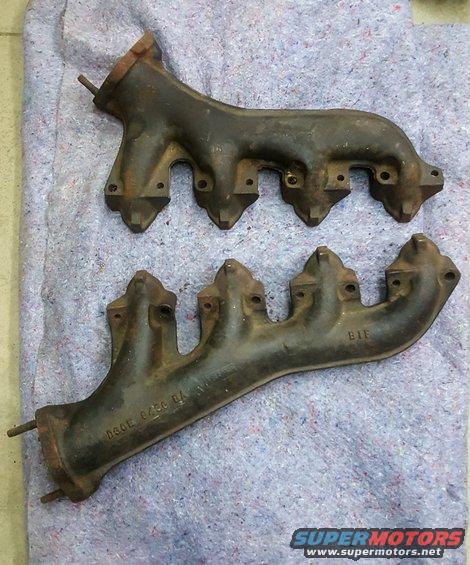 two cast iron exhaust manifolds on a blanket
