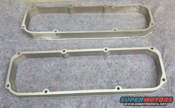 pair of aluminum valve covers on a gray carpeted surface