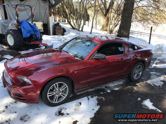 Red 2014 Ford Mustang coupe parked in snow