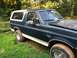 1993 Ford Bronco - The 1993 Ford Bronco is seen from a three-quarter front angle, parked outdoors on a grassy area.