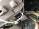 1995 Ford Bronco - A close-up view of a vehicle's interior wiring harness, with a hand connecting a yellow wire.