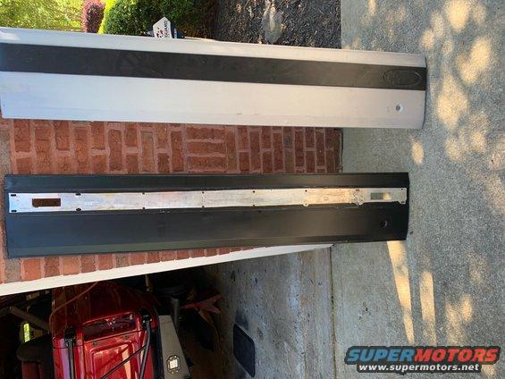 two vehicle door trim pieces, one silver with black stripe, one black with silver insert
