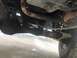 1995 Ford Bronco - A close-up view of the vehicle's undercarriage reveals its suspension components and exhaust system.