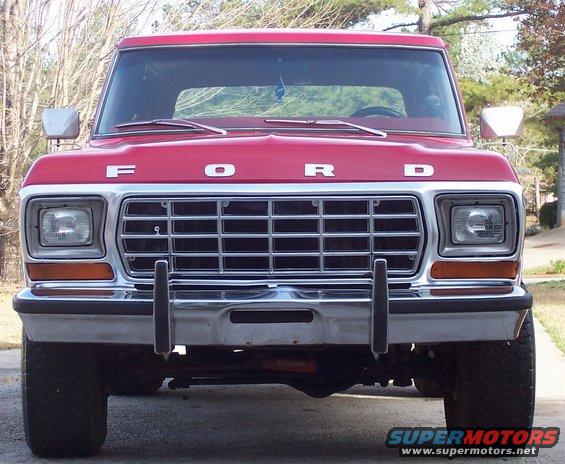 front view of red Ford truck with chrome grille and 'FORD' lettering on hood