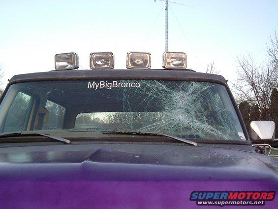 Purple Ford Bronco front view, cracked windshield, four roof lights, "MyBigBronco" sticker on glass