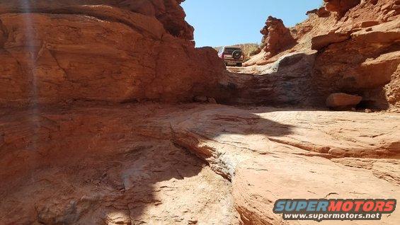 Rear view of an SUV on a narrow, rocky desert trail