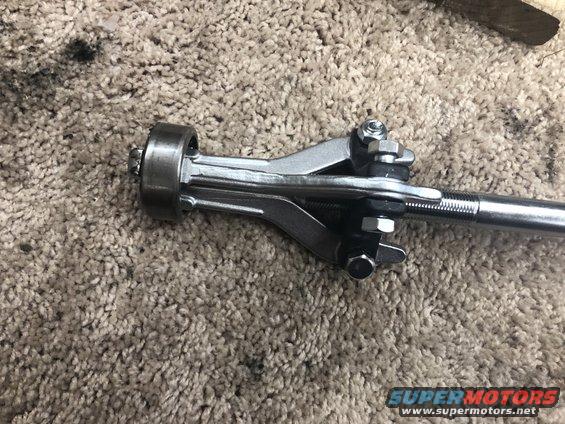 Tie rod end with adjustment sleeve on carpet. Supermotors.net logo visible