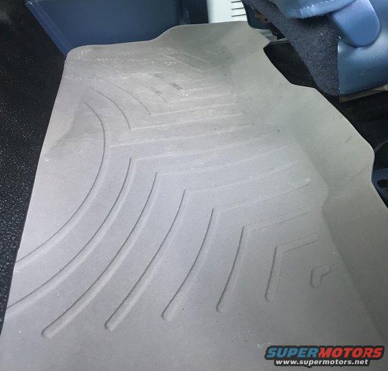 WeatherTech floor mat with embossed pattern and logo, inside a vehicle