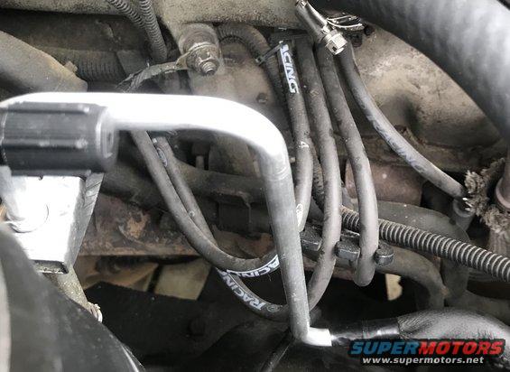 engine bay showing spark plug wires with 'RACING' text, AC unit pipe, and SuperMotors logo