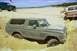 1979 Ford Bronco - Two SUVs and a pickup truck are on a sandy terrain, with one Bronco deeply stuck in the sand.