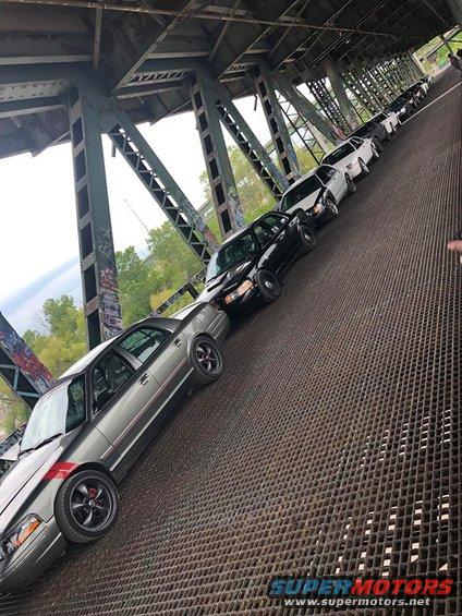 Line of 2004 Ford Crown Victoria police cars parked on a metal grate bridge