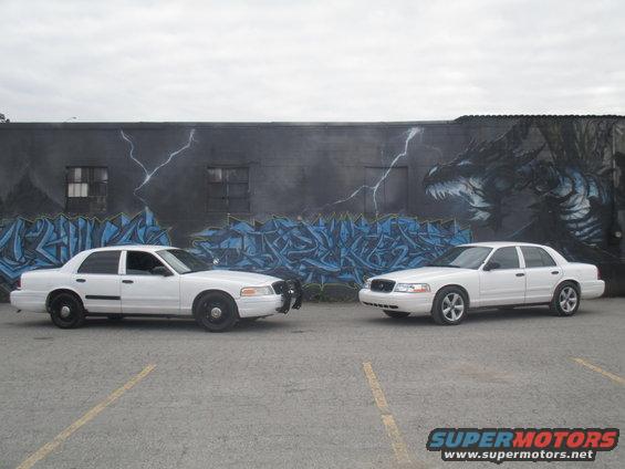 Two white 2004 Ford Crown Victorias parked side-by-side