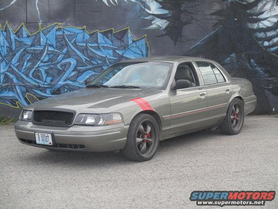 Gray sedan with red racing stripes on fender and door trim, black grille, custom wheels