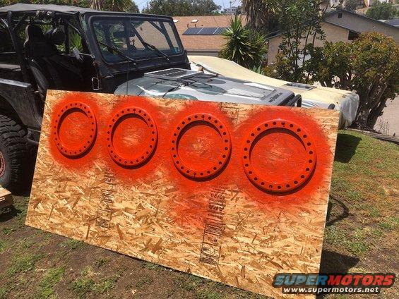 Jeep Wrangler parked behind plywood with four orange circles spray-painted on it