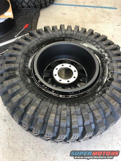 Off-road tire mounted on a black wheel with silver lug nuts
