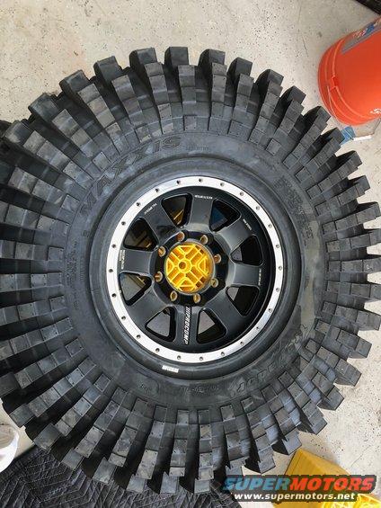Maxxis off-road tire on a black wheel with yellow center cap