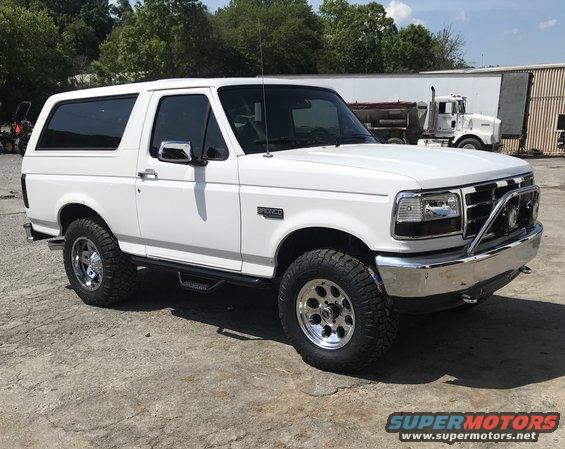White 1995 Ford Bronco parked on concrete, chrome bull bar on front bumper