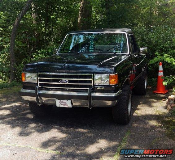 Black Ford F-150 pickup truck with chrome grille and bumper, parked outdoors