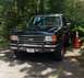 1988 Ford Bronco - Front view of a black 1987 Ford F-150 pickup truck with a red stripe on the side.