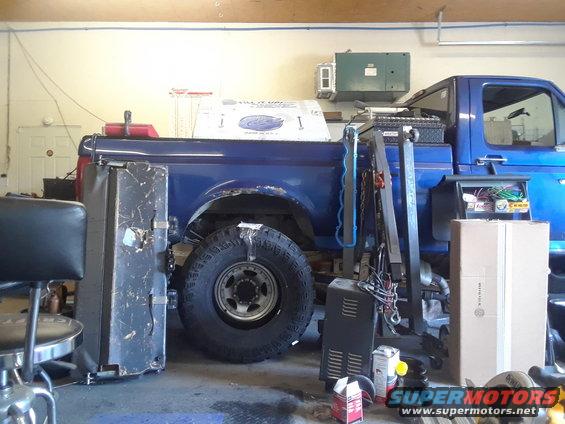 Blue pickup truck bed and large rear wheel with off-road tire