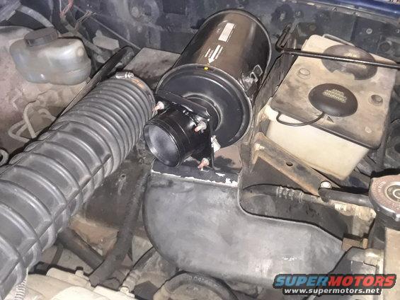 Engine bay showing air intake hose, air filter housing, and fluid reservoirs