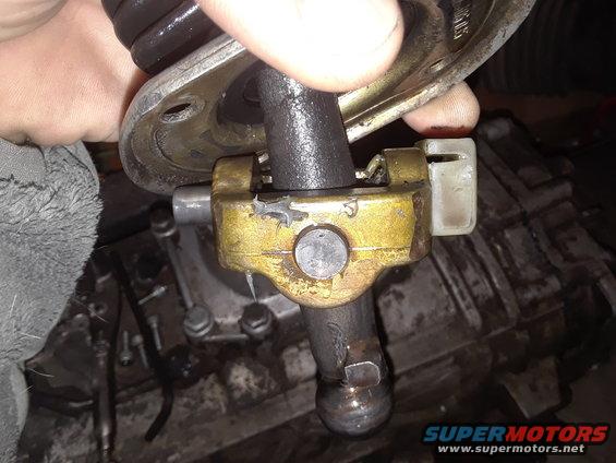 Manual transmission shifter linkage with yellow bracket and black shift lever