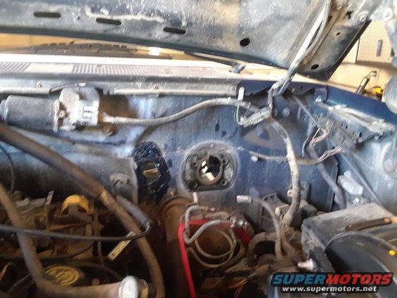 Engine bay with wiring harness, master cylinder, and brake booster visible. Some components appear to be removed