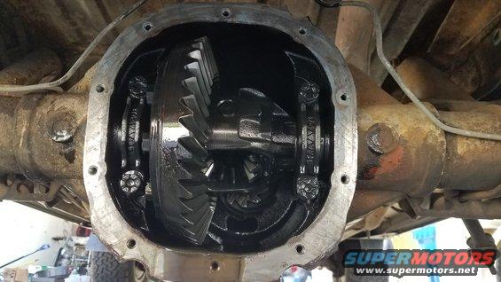 Open differential housing showing ring and pinion gears. Some bolts are visible