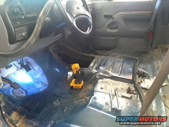 1996 Ford F-350 interior with floor removed, showing transmission tunnel and tools