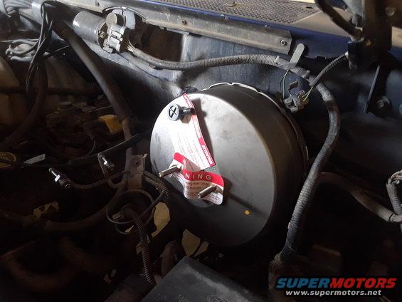 Brake booster with red warning tags and visible wiring