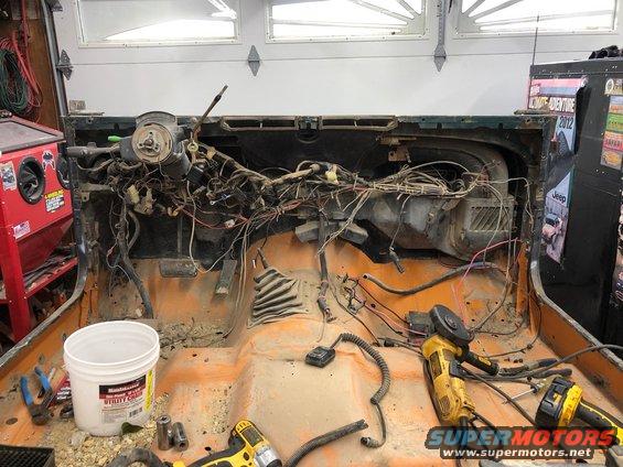 Jeep interior with dashboard removed, wires exposed, tools on floor