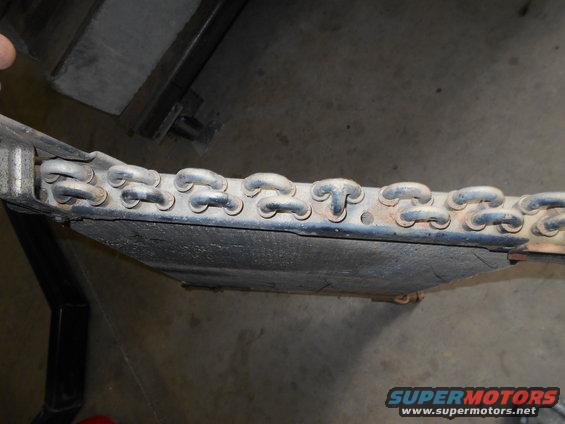 Close-up of a metal chain assembly on a vehicle's undercarriage