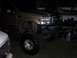 2000 Ford F-450 - A lifted gold Ford F-450 truck with oversized tires is parked indoors.