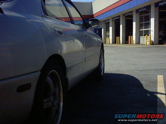 Silver sedan side view parked in front of auto service bays