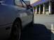 1995 Mazda 626 - A silver sedan is parked in front of auto service bays, its side profile visible.