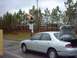 1995 Mazda 626 - Silver 1995 Mazda 626 sedan with its trunk open, positioned near a traffic light and industrial scales.